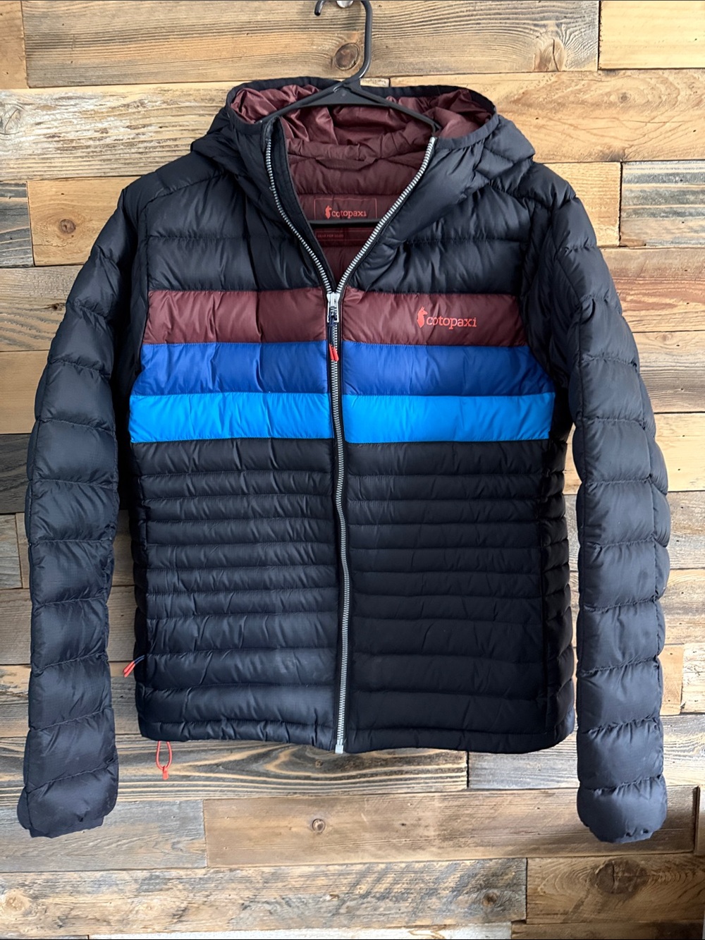 cotopaxi Black Puffer Jacket with Maroon and Blue Chest Stripes